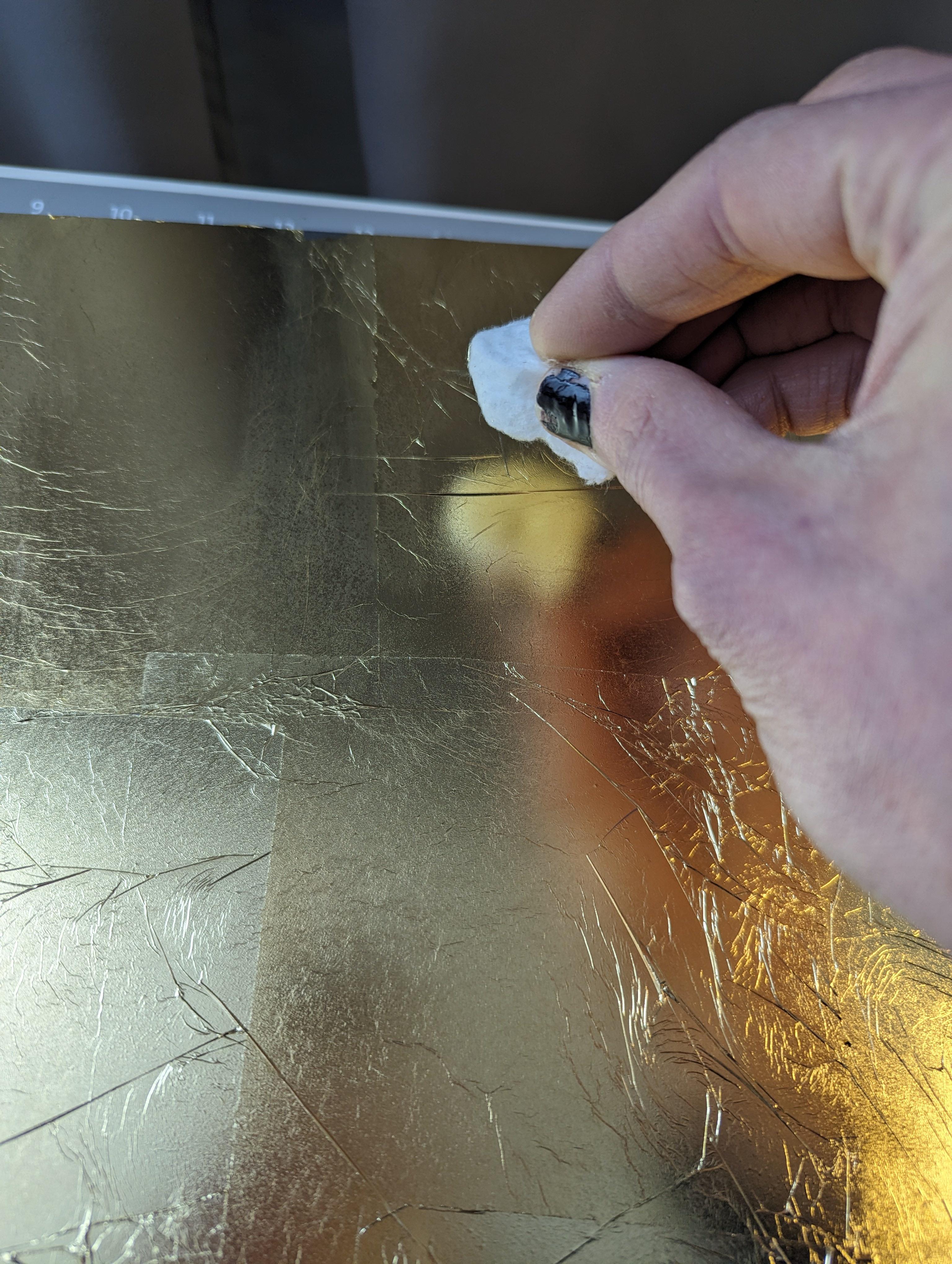 Burnishing the gilding with a cotton ball