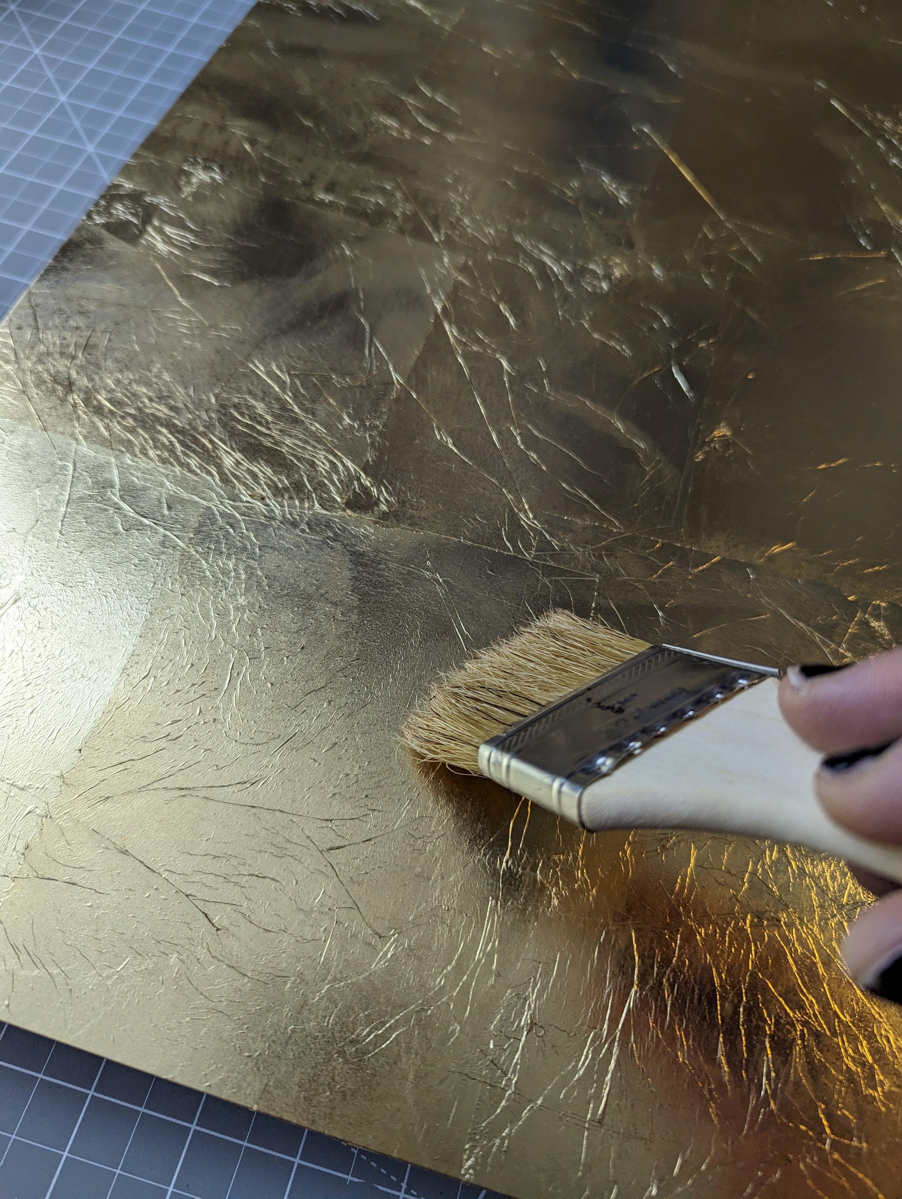 Spreading shellac to protect the gold leaf